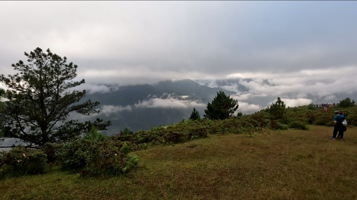 Panoramic view of rolling green hills with mountains in the distance. (Sagada, Mountain Province, Philippines)